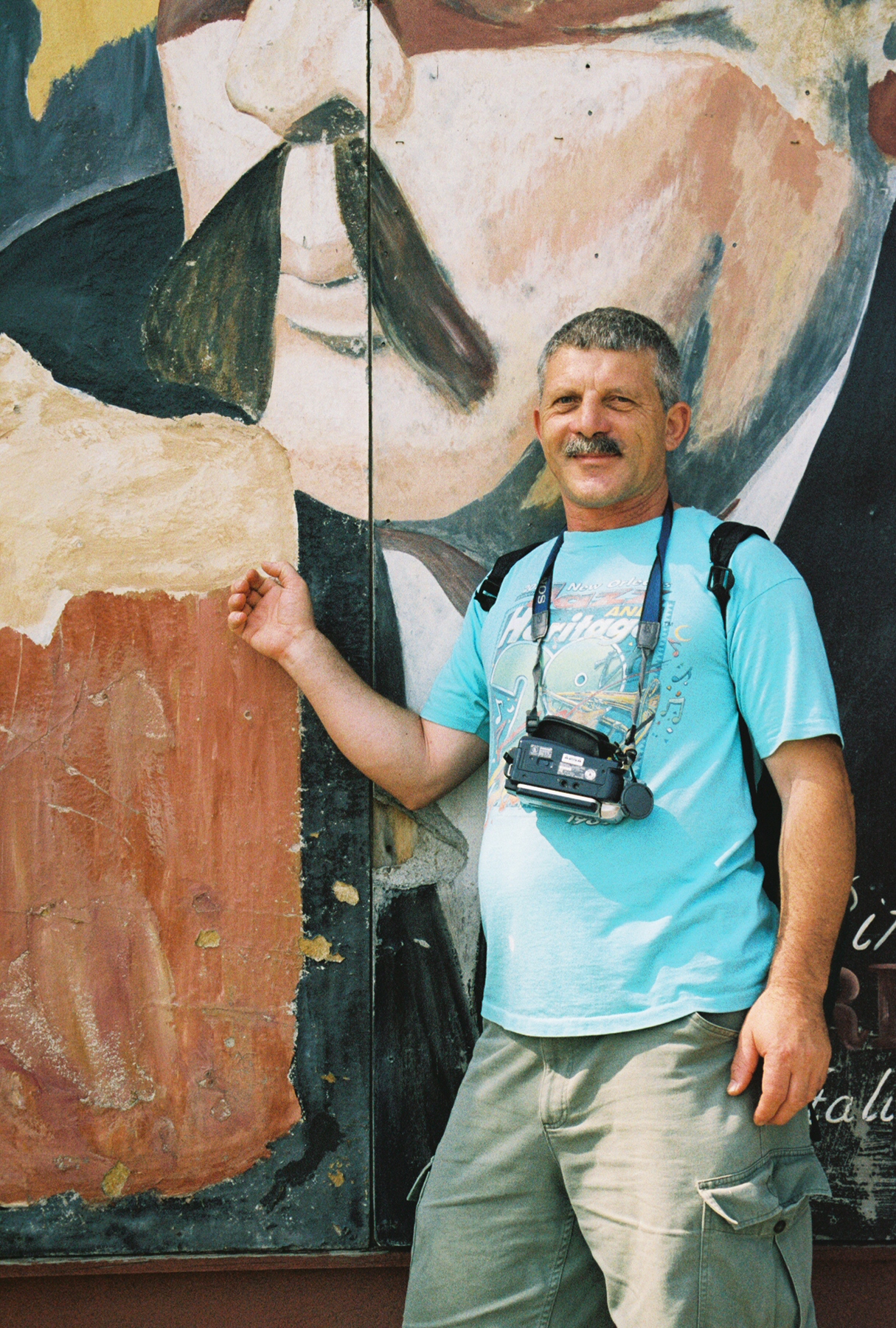 Francesco posing in front of a mural with a mustache in Chicago